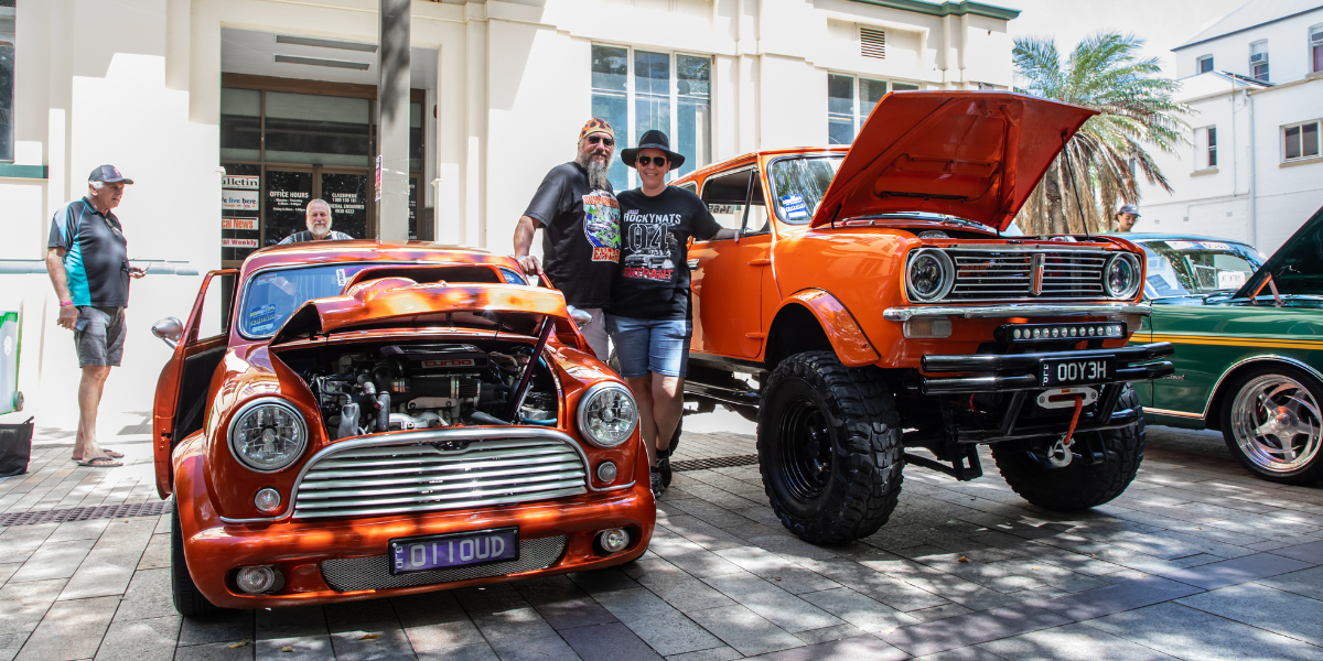 Classic cars on display at Rockynats festival with enthusiasts admiring the vehicles