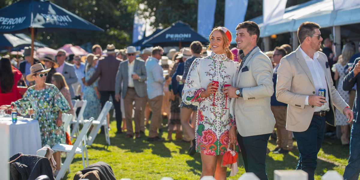 Young couple enjoying a drink in the crowd at Rockhampton's Pop-Op Polo