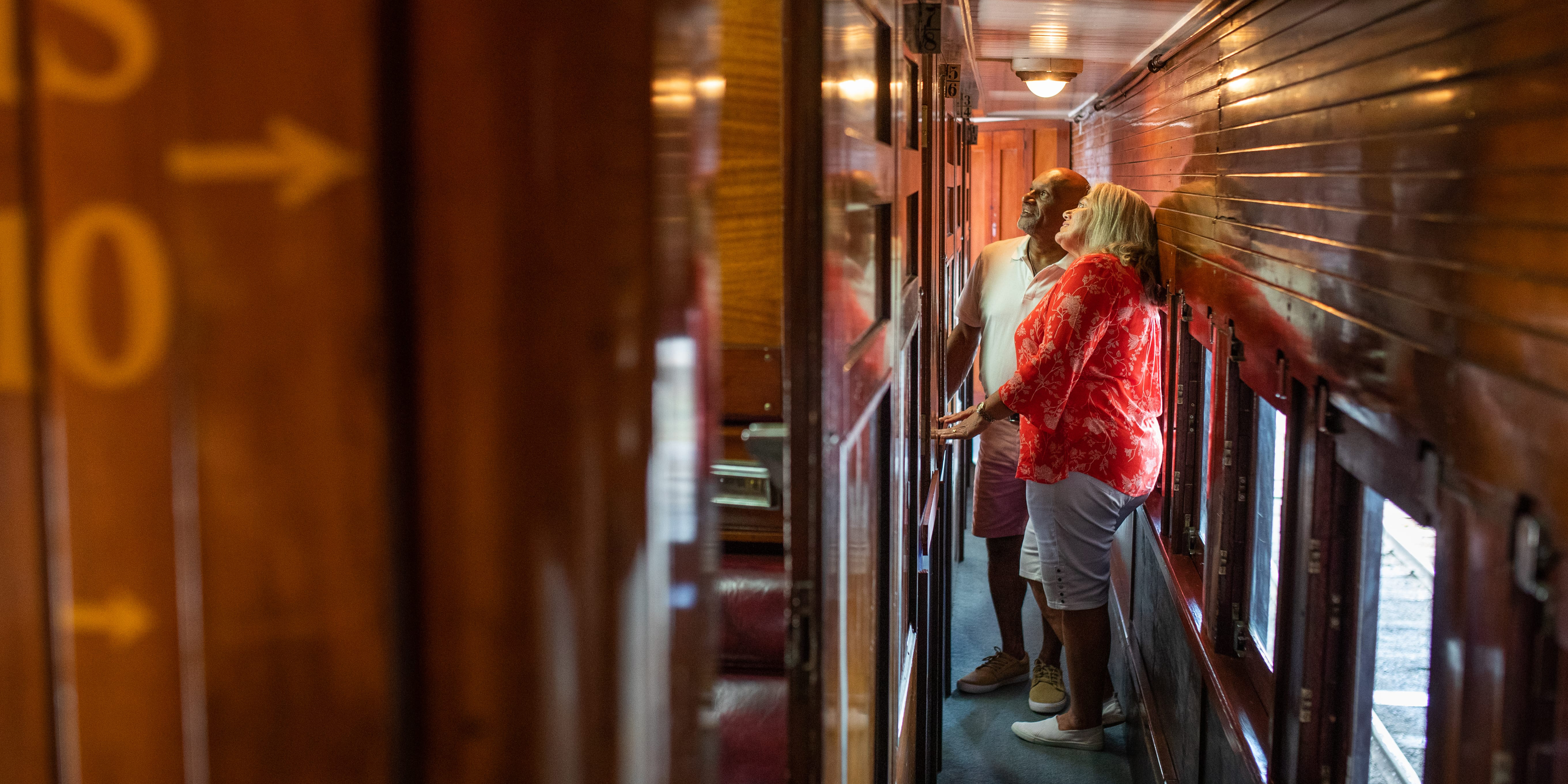 Middle aged couple looking through the interior of a historical train carriage