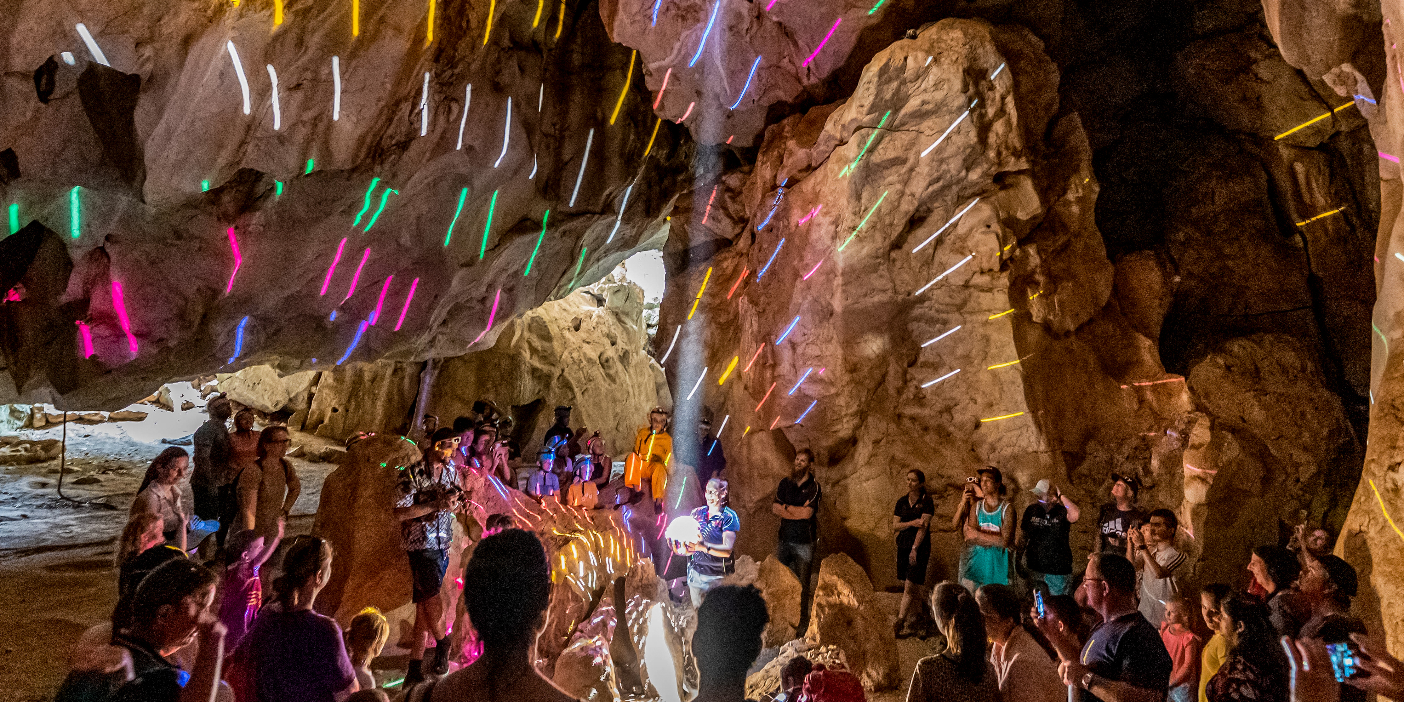 Lady holds disco ball during summer solstice at the Capricorn Caves