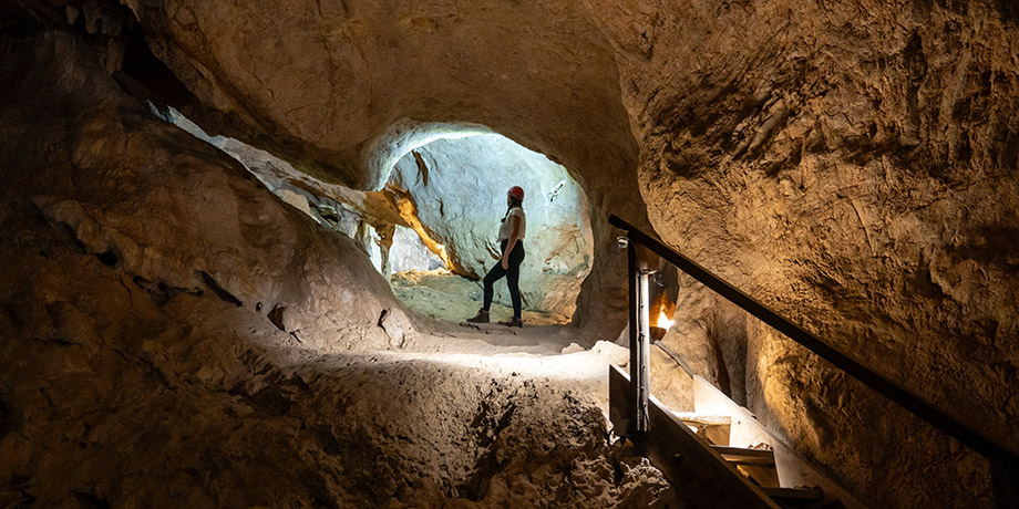 A young woman admiring the inside of an ancient cave dwelling.