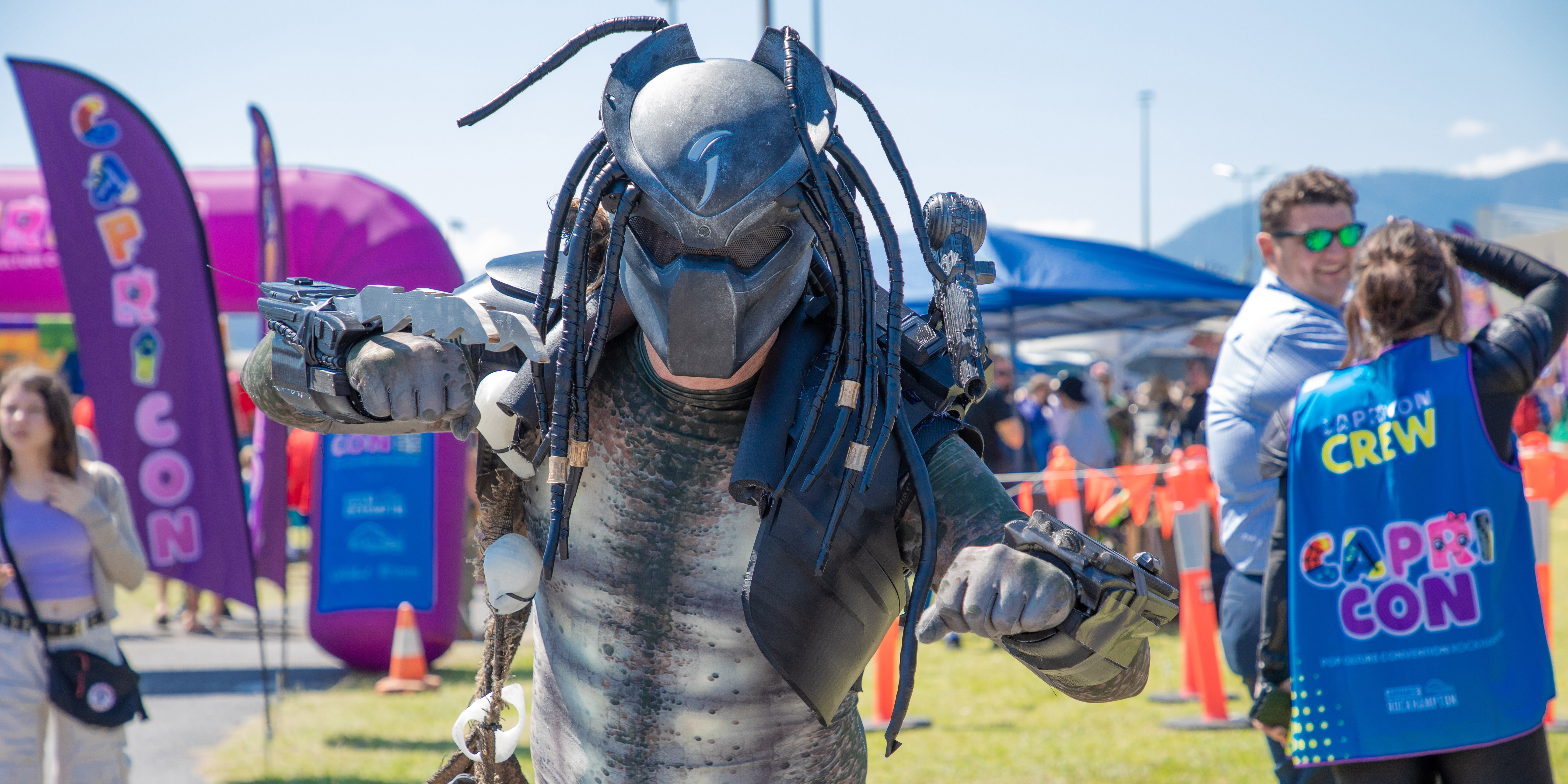 Person dressed up as Predator performing a fighting pose for the camera.