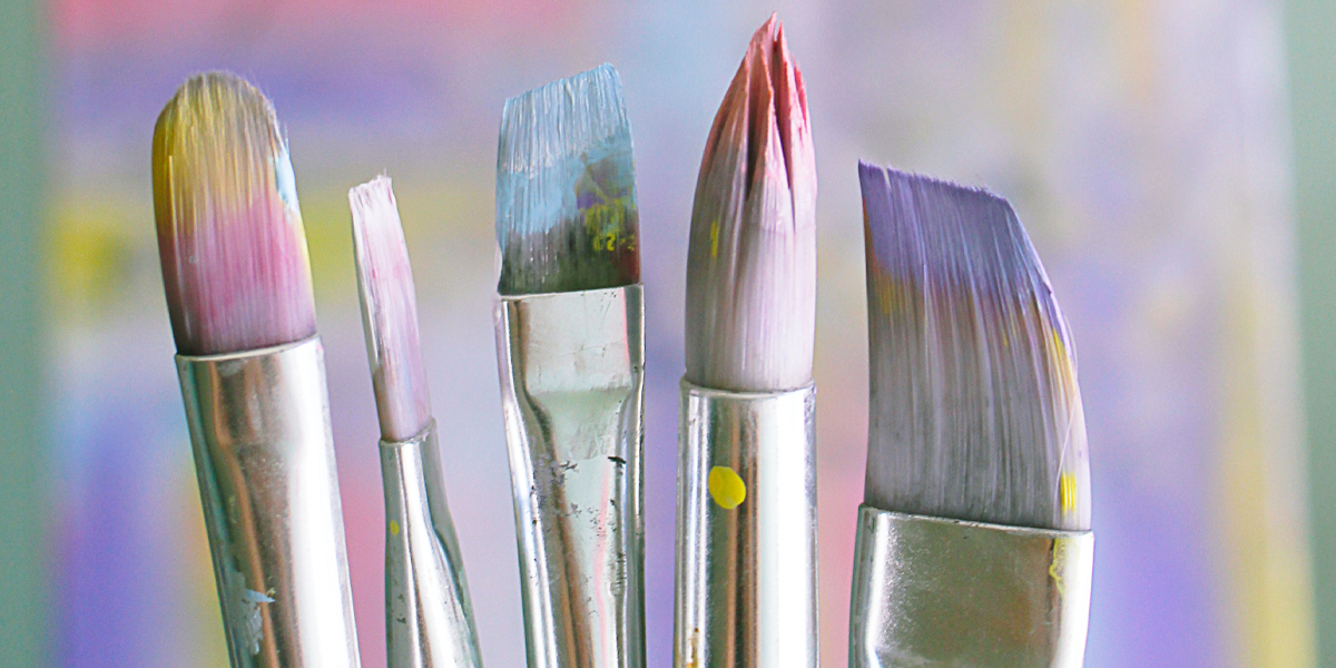 Close up of different size paint bushes with pastel colours